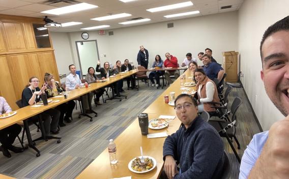 Achilefu Lab team sitting around a U-shaped line of tables eating lunch.