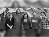 Six people standing in front of mural