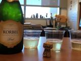 Champaign bottle, cork, and three filled glasses on table