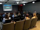 people in an auditorium looking at a screen