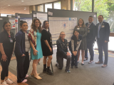 people next to a poster presentation
