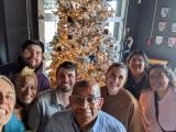 Nijhawan Lab standing in front of a golden decorated christmas tree
