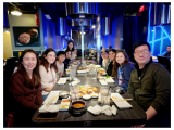 Eight men and women seated at a restaurant table, surrounded by ultra-modern decor. 