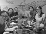 Seven people at a table in a restaurant with a seafood mural behind them.