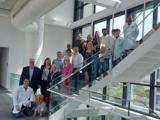 A large group of people and a dog pose for the camera on stairs