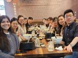 Eleven men and women seated at a restaurant table.