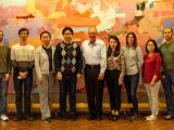 9 team members posed in front of an abstract art exhibit.