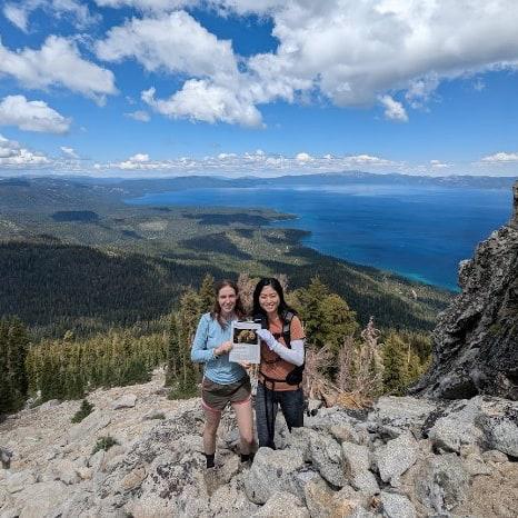 two people standing on Rubicon Peak above Lake Tahoe