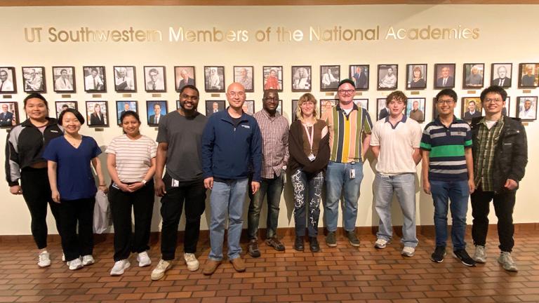 Stone Chen Lab members standing infront of the National Academies wall