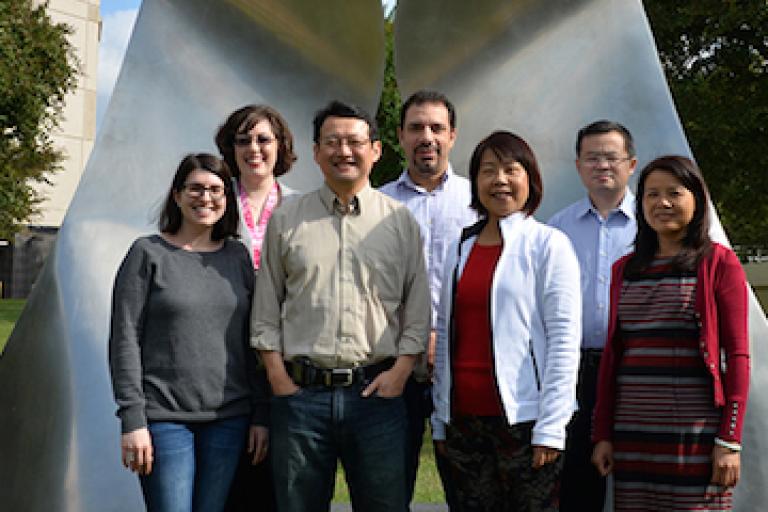 Group photo in front of an abstract sculpture.