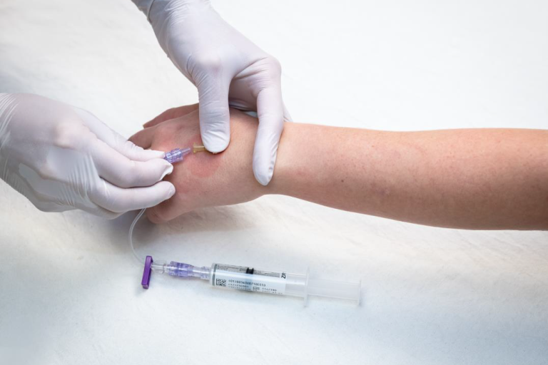 nurse setting an IV tube in patient arm