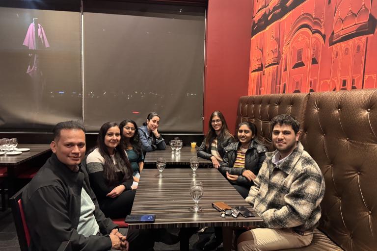 A group of seven people sitting down in restaurant booths.