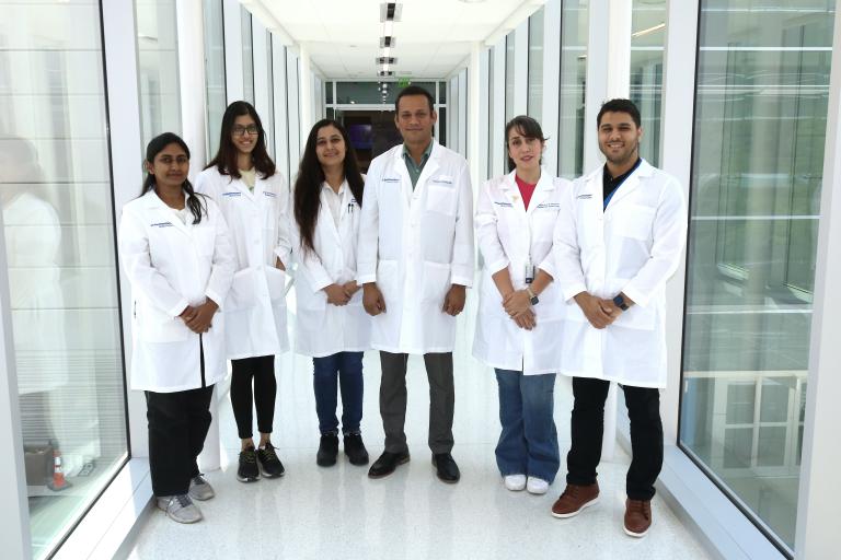 A group of people in white lab coats on a skybridge.