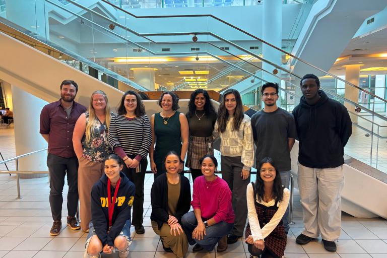 Dr. Routzong and colleagues pose in front of stairs at the Women's Health Research Symposium