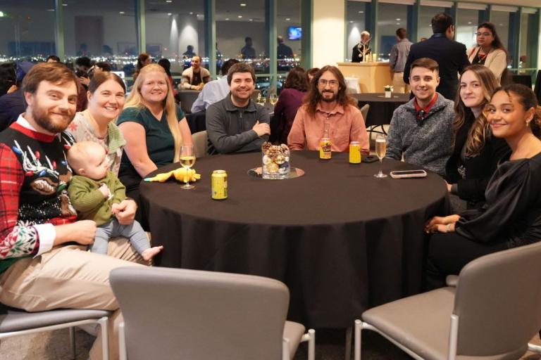 Dr. Routzong and members of the Biomedical Engineering Department seated at table during holiday party