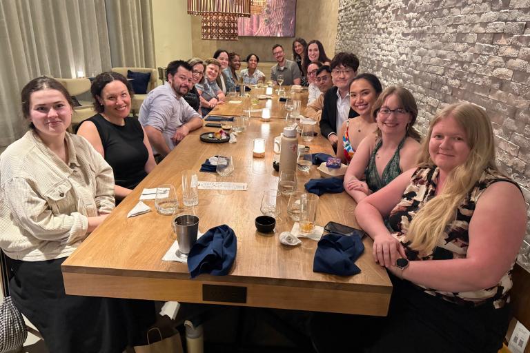 Dr. Routzong and colleagues seated at a long table in a restaurant during (SRI) Annual Meeting