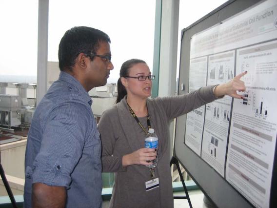 Two team members looking at poster board