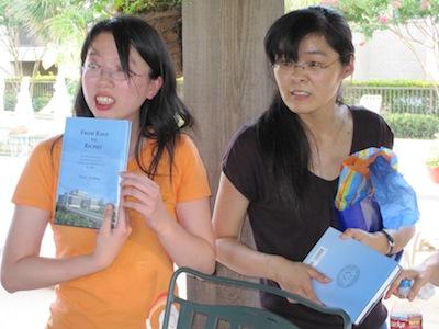 Two team members at pool party h holding books