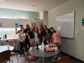 Lab team gathered in a break room with refreshments.