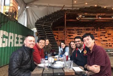 Seven lab team members sitting at a picnic table.