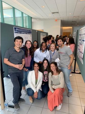 Nine lab team members at poster presentation.
