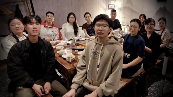 Lab members gathered around table for hot pot lunch 