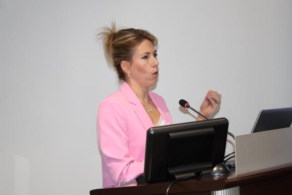 Dr. Maude Carmel standing at podium speaking