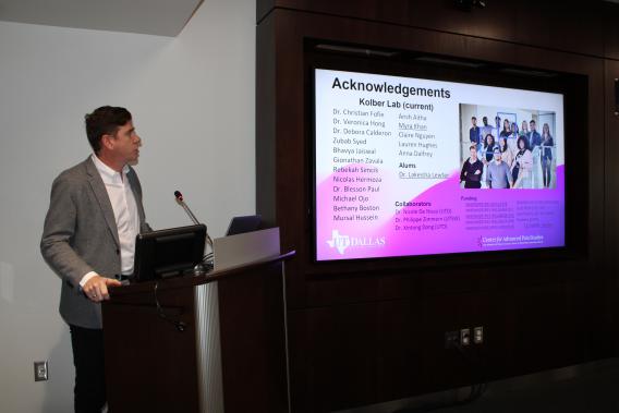 Dr. Benedict Kolber presenting a presentation at a podium