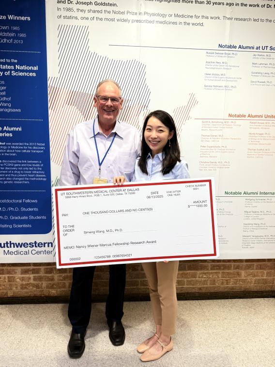 Jay Horton and Simeng Wang smiling for photo with award check