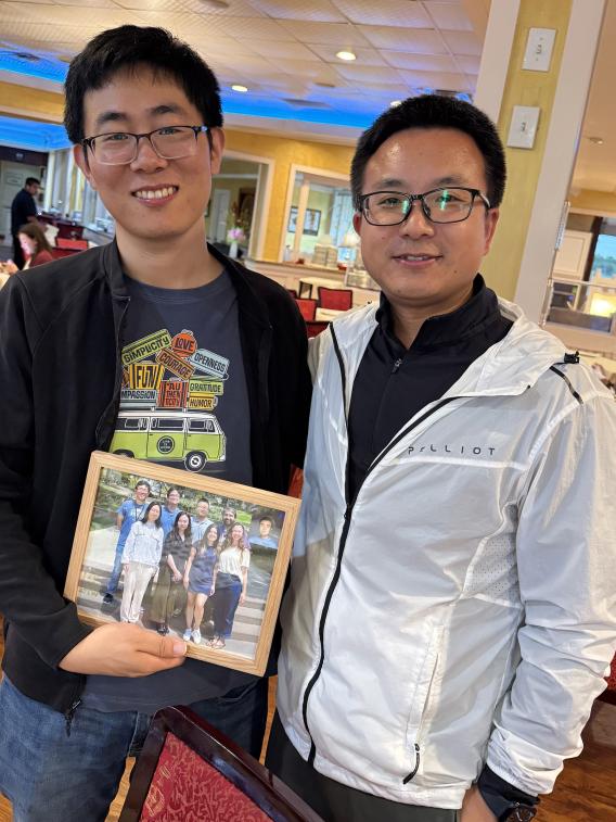 Dr. Sun with Tingxin holding lab group picture