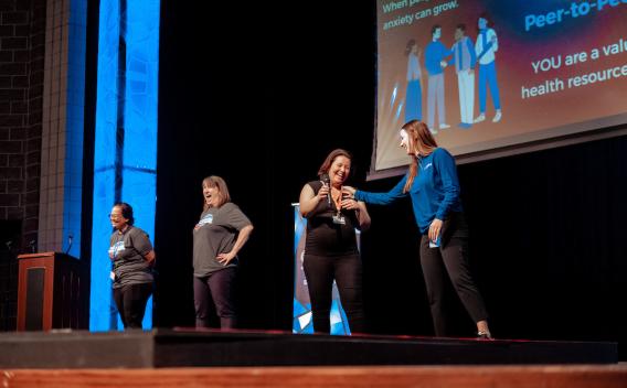 Four women presenting on a stage