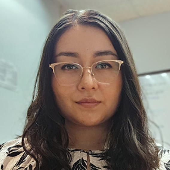 Young woman with long, dark hair and glasses.