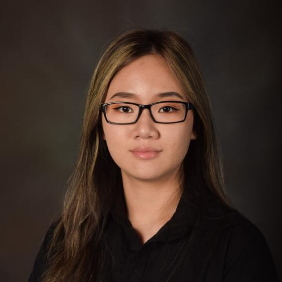 Woman with highlighted hair wearing glasses and a black blouse.