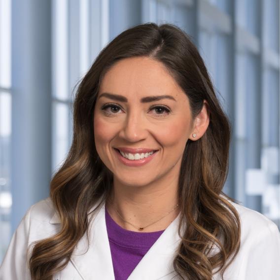 a woman with long brown hair wearing a white coatPlaceholder image