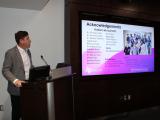 Dr. Benedict Kolber presenting a presentation at a podium