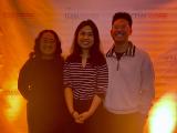Three people posing together.