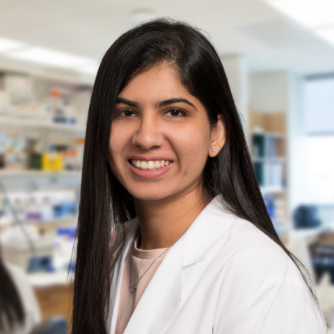 Placeholder ima woman with long dark hair wearing a white lab coat standing in a brightly lit laboratoryage