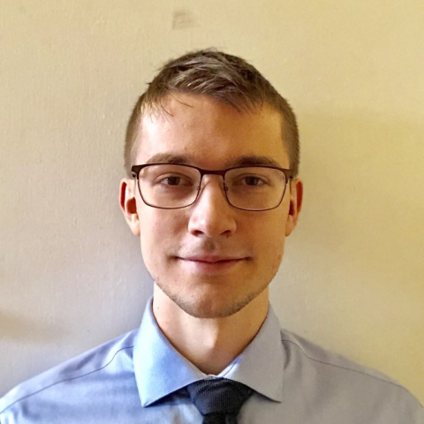 Headshot of a man against a blank wall