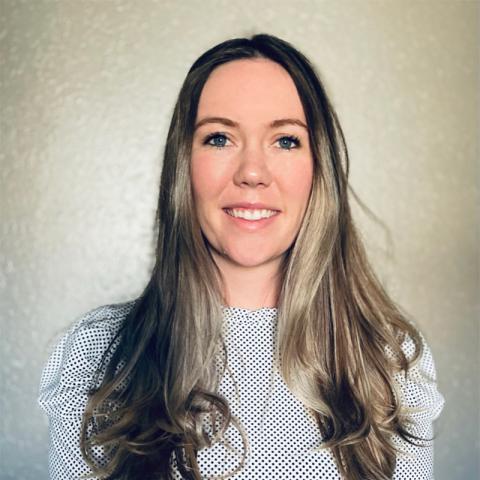 a woman with long hair and a black and white polka dot shirt