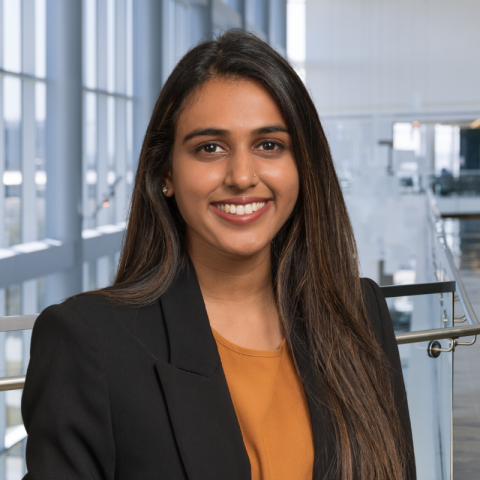 Dr. Mausam Patel wearing a dark blazer and orange blouse in the lobby of Clements University Hospital.